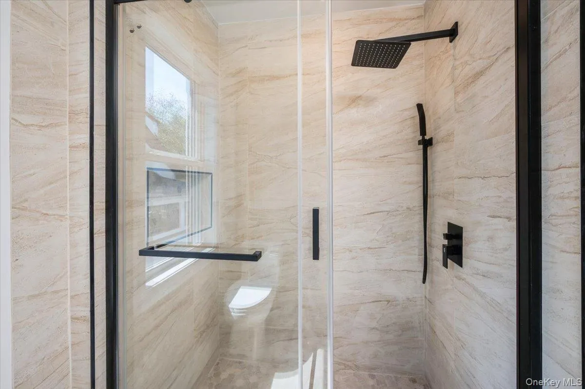 Bathroom featuring a marble finish shower Bathroom featuring a marble finish shower
