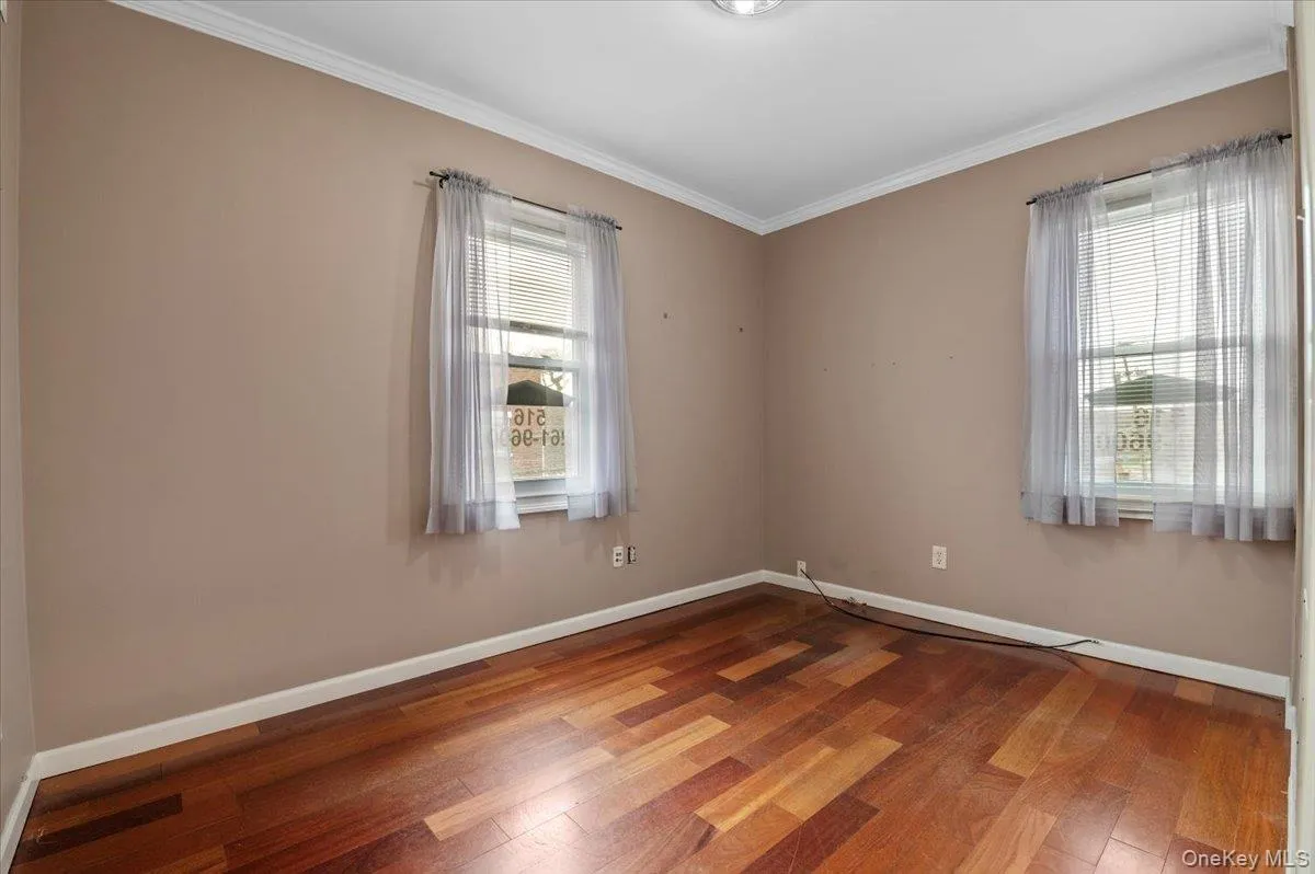 Spare room with ornamental molding and wood finished floors Spare room with ornamental molding and wood finished floors
