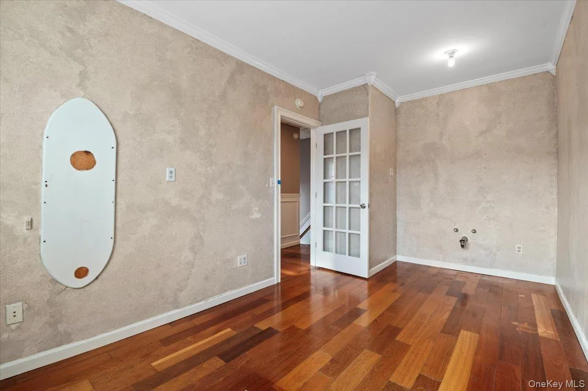 Unfurnished room featuring crown molding, dark wood-style floors, and a baseboard radiator Unfurnished room featuring crown molding, dark wood-style floors, and a baseboard radiator