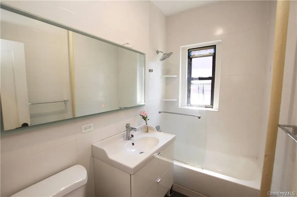 Full bath featuring shower / bathtub combination, vanity, and tile walls Full bath featuring shower / bathtub combination, vanity, and tile walls