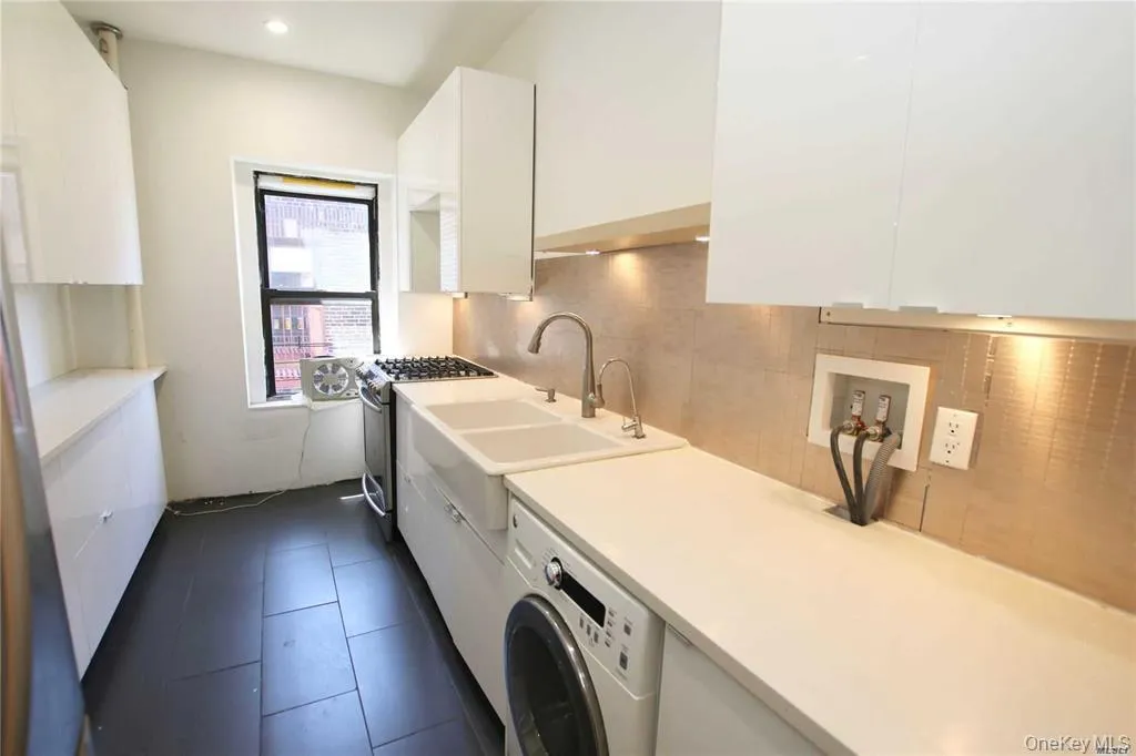 Laundry area with washer / dryer, dark tile patterned floors, and recessed lighting Laundry area with washer / dryer, dark tile patterned floors, and recessed lighting