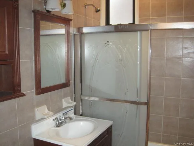 Bathroom featuring tile walls and vanity Bathroom featuring tile walls and vanity