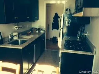 Kitchen featuring blue cabinets, exhaust hood, and dark tile patterned flooring Kitchen featuring blue cabinets, exhaust hood, and dark tile patterned flooring