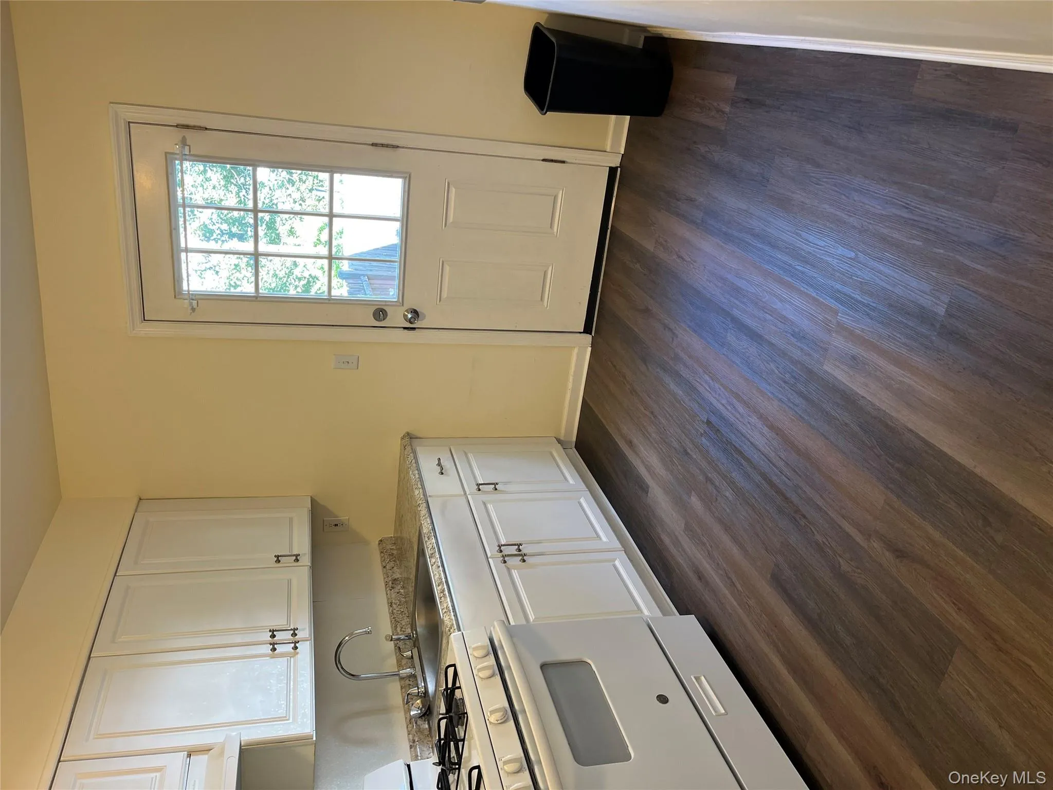 Kitchen featuring stove, white cabinetry, dark wood-style flooring, and extractor fan Kitchen featuring stove, white cabinetry, dark wood-style flooring, and extractor fan