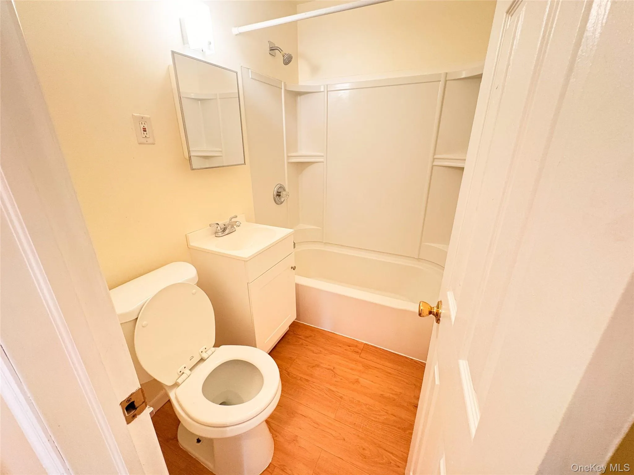 Full bathroom with light wood-style flooring, vanity, and shower / bathtub combination Full bathroom with light wood-style flooring, vanity, and shower / bathtub combination