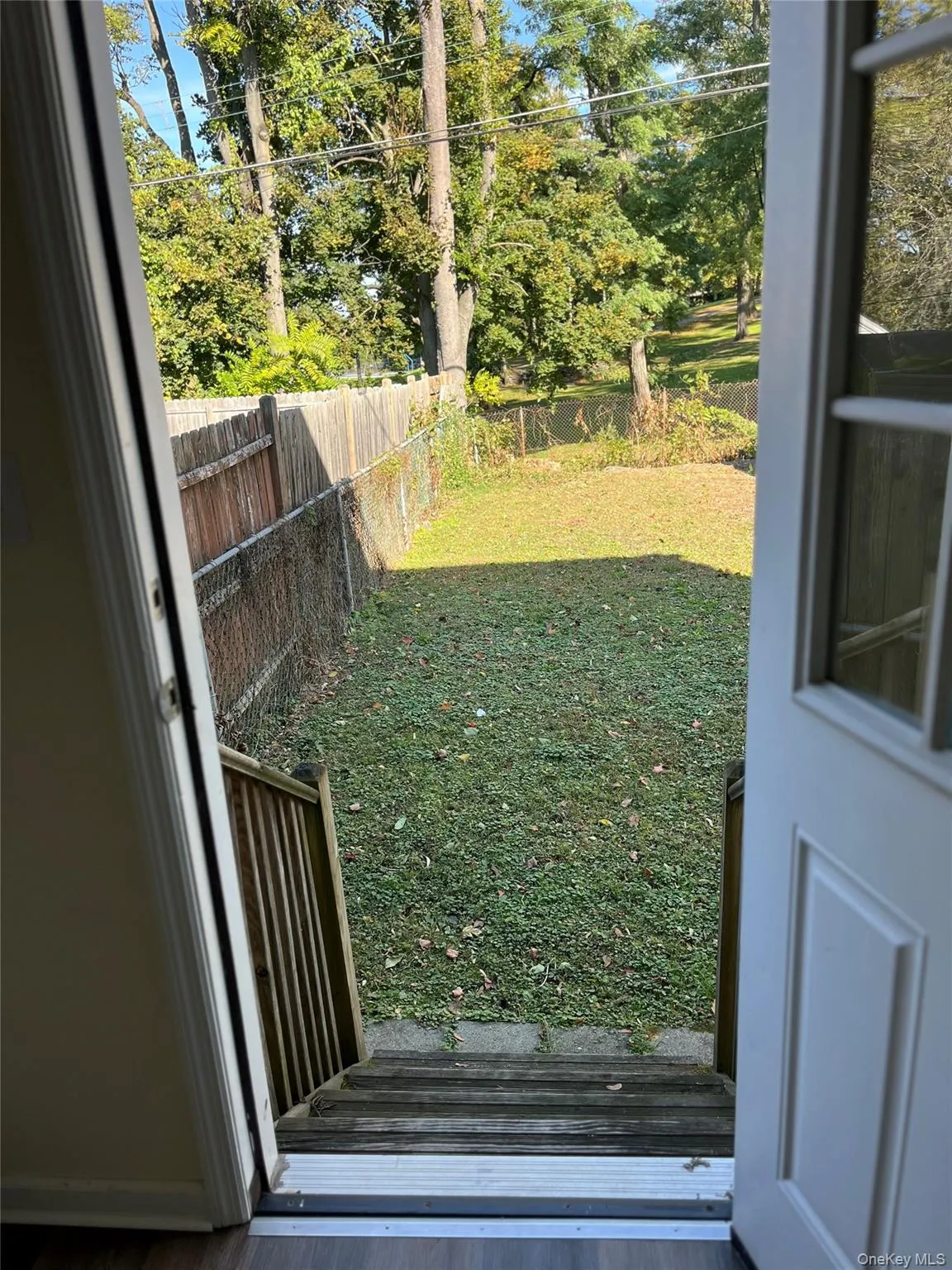 Fenced backyard with a wooden deck Fenced backyard with a wooden deck