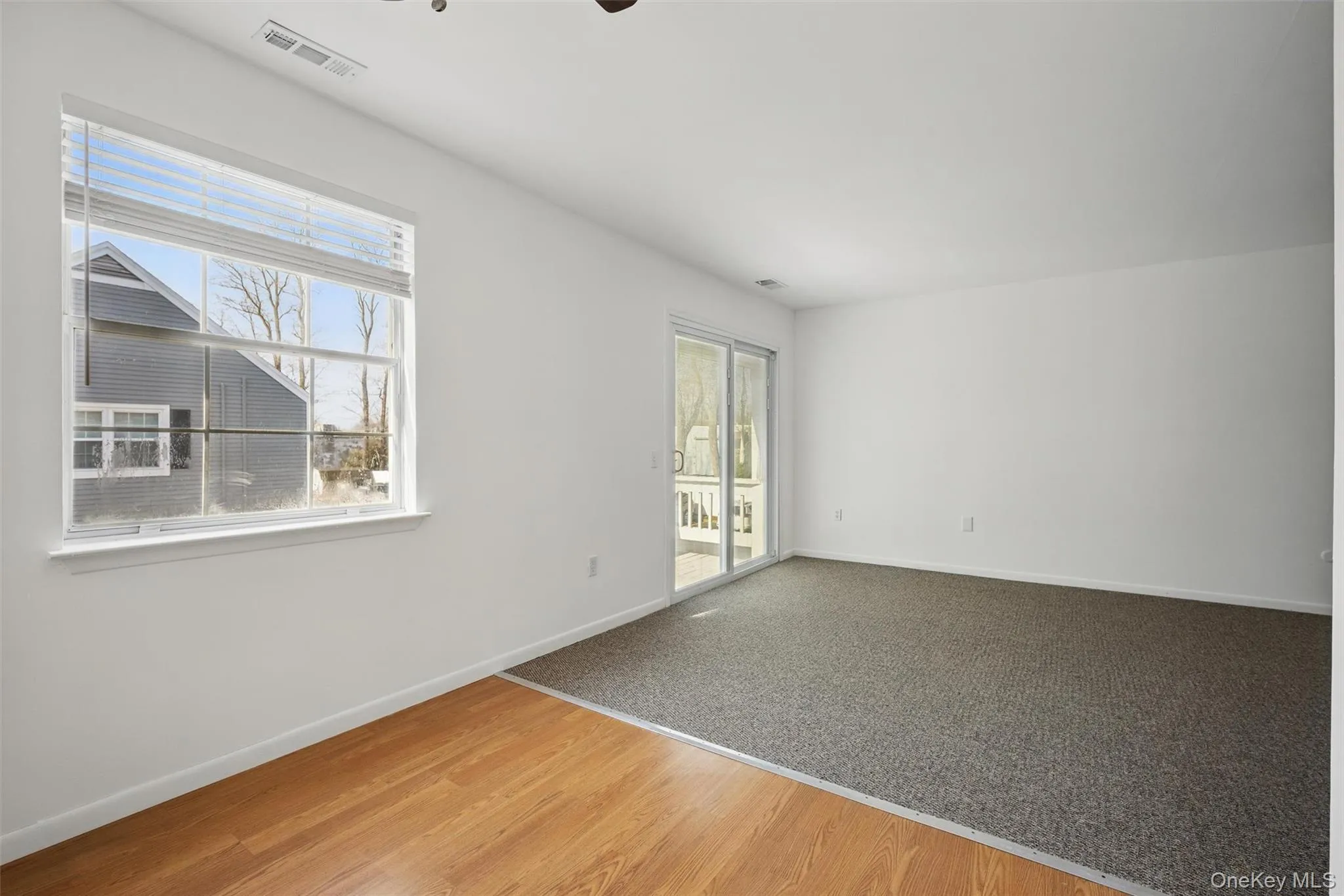 Empty room featuring wood finished floors, plenty of natural light, and a ceiling fan Empty room featuring wood finished floors, plenty of natural light, and a ceiling fan