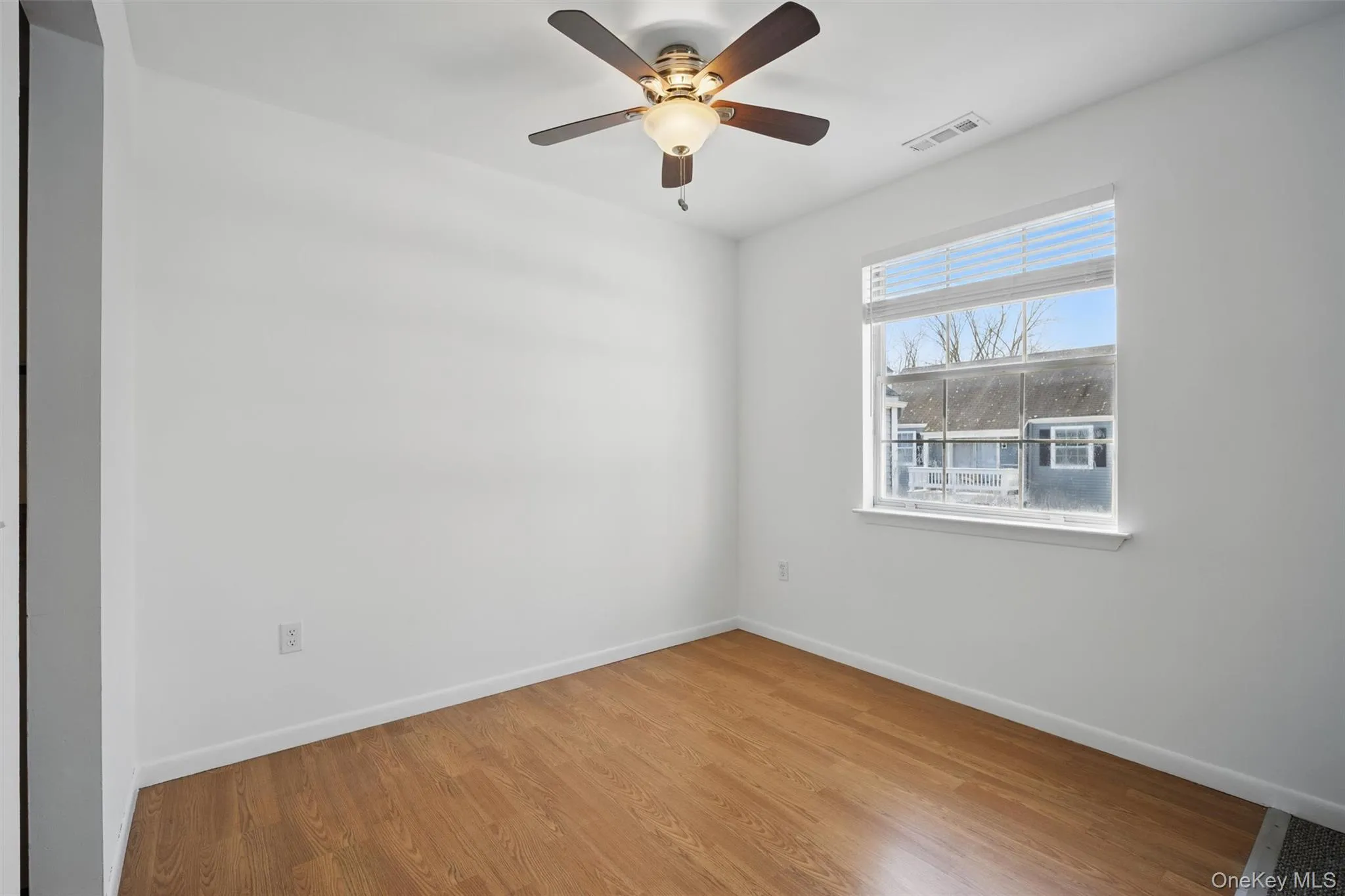 Unfurnished room featuring wood finished floors and a ceiling fan Unfurnished room featuring wood finished floors and a ceiling fan