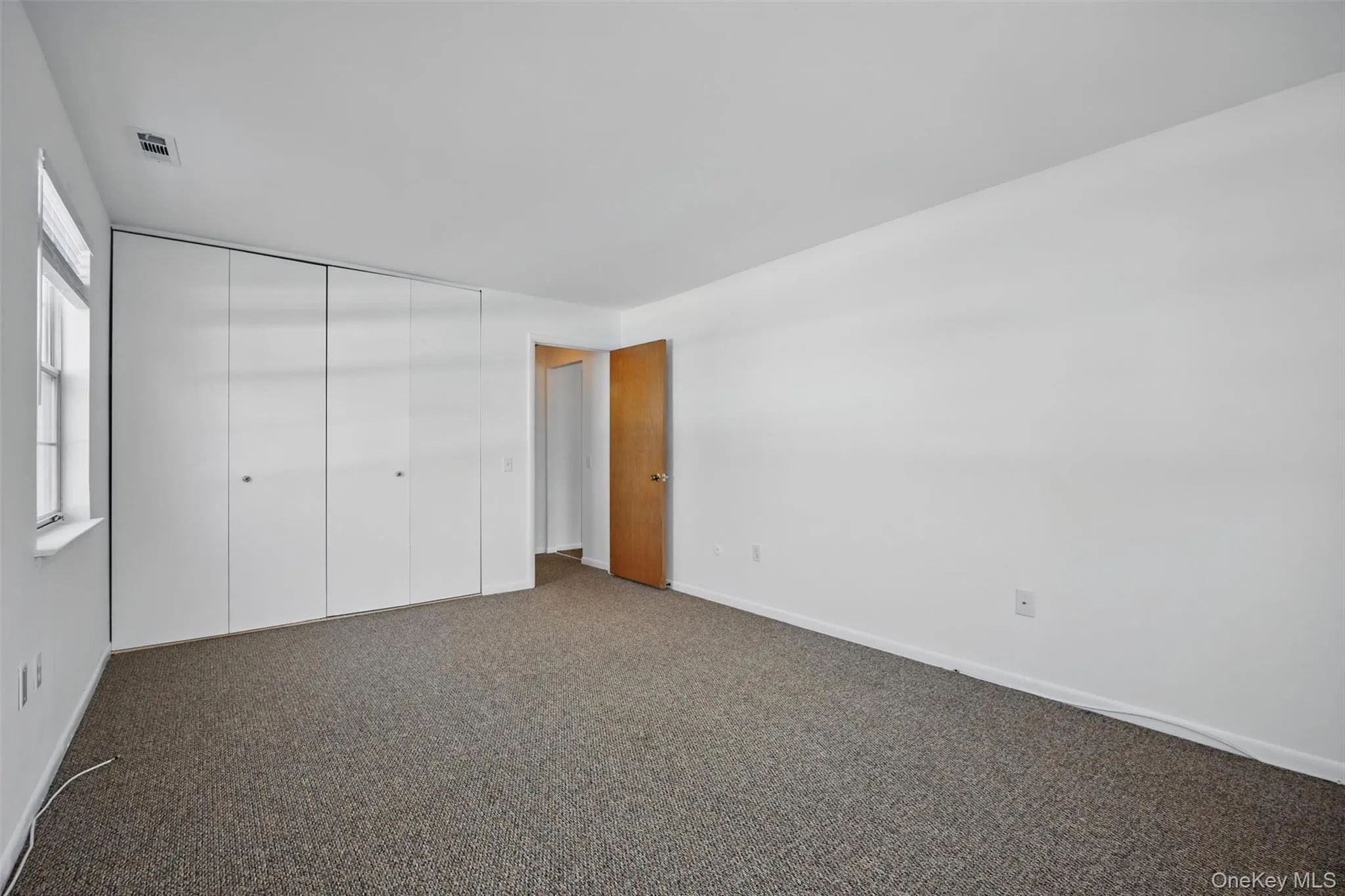 Unfurnished bedroom featuring carpet flooring and a closet Unfurnished bedroom featuring carpet flooring and a closet