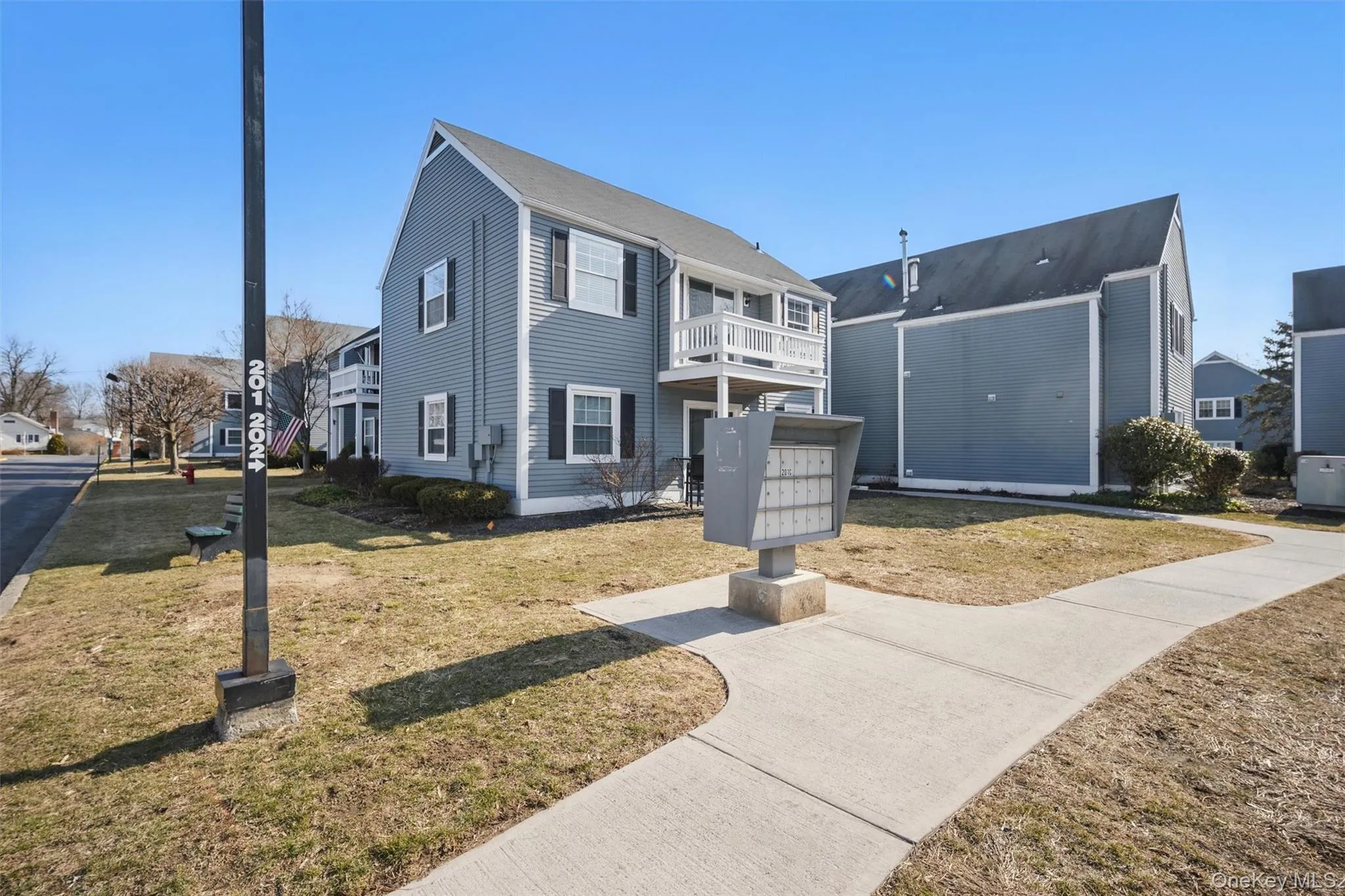 View of front of house with a balcony, a front yard, and a residential view View of front of house with a balcony, a front yard, and a residential view