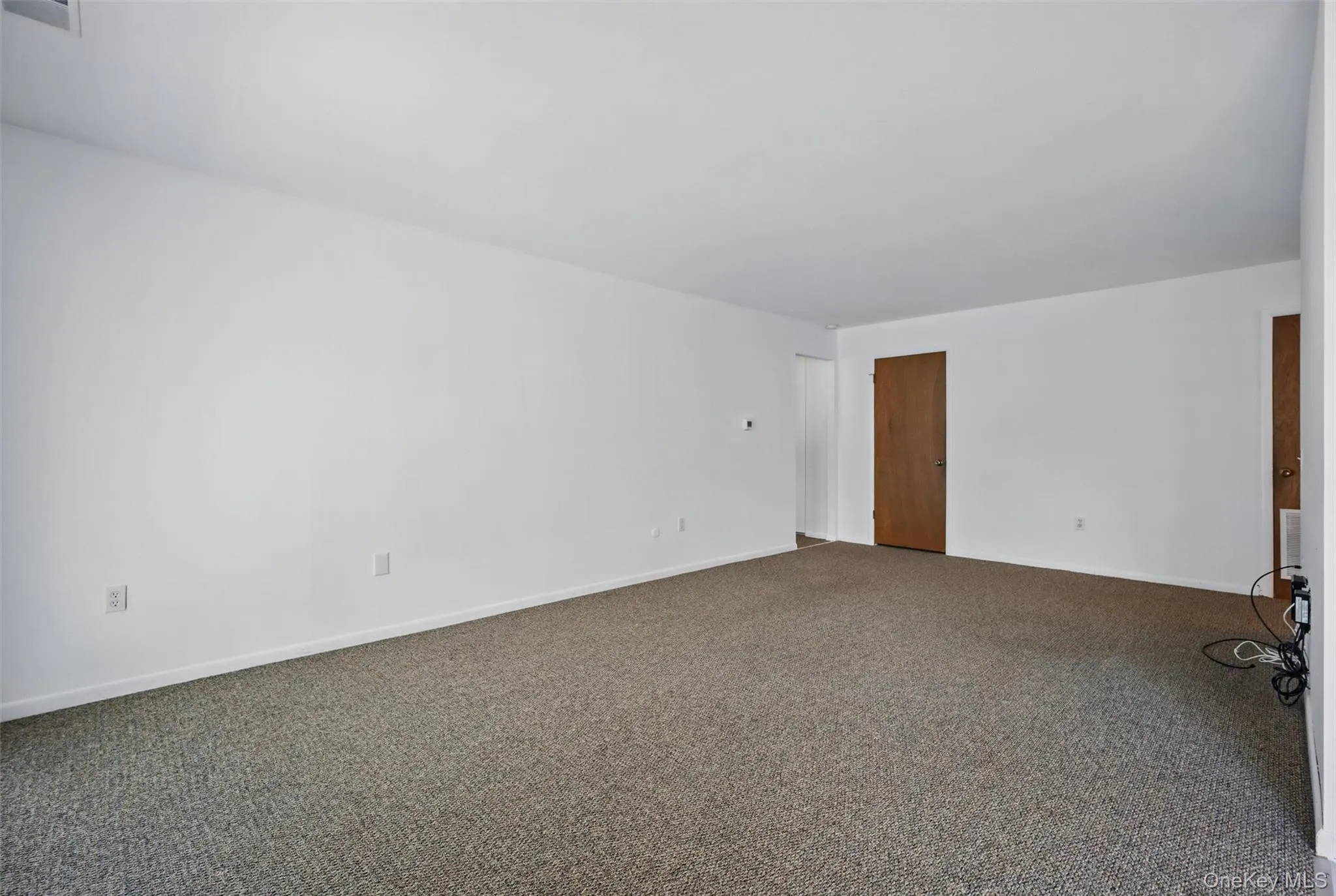 Unfurnished room featuring carpet flooring and baseboards Unfurnished room featuring carpet flooring and baseboards