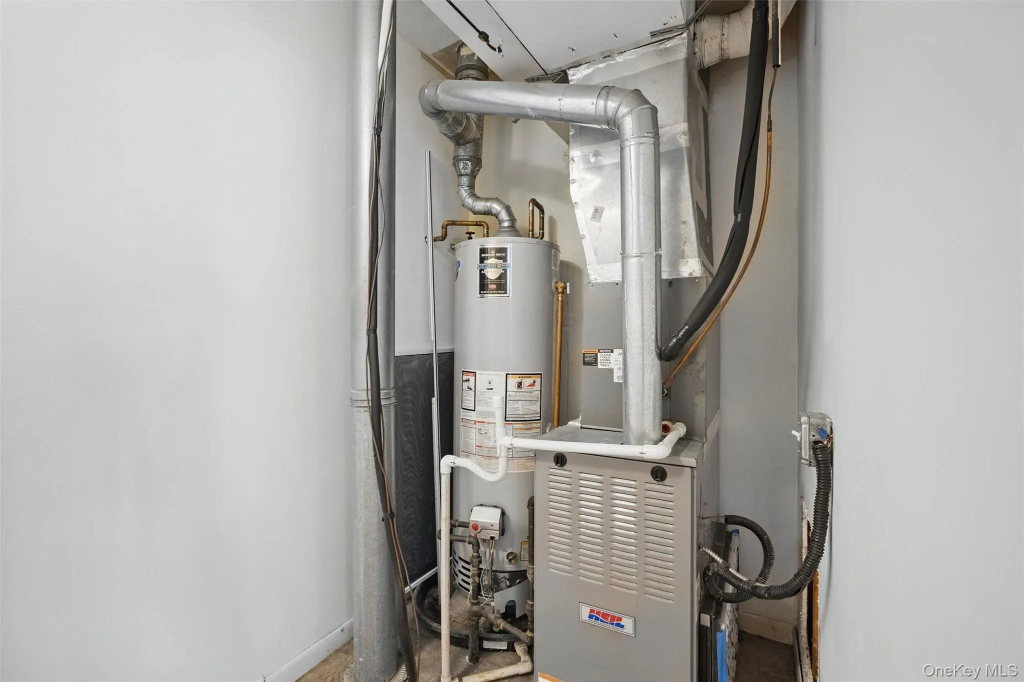 Utility room featuring heating unit and water heater Utility room featuring heating unit and water heater