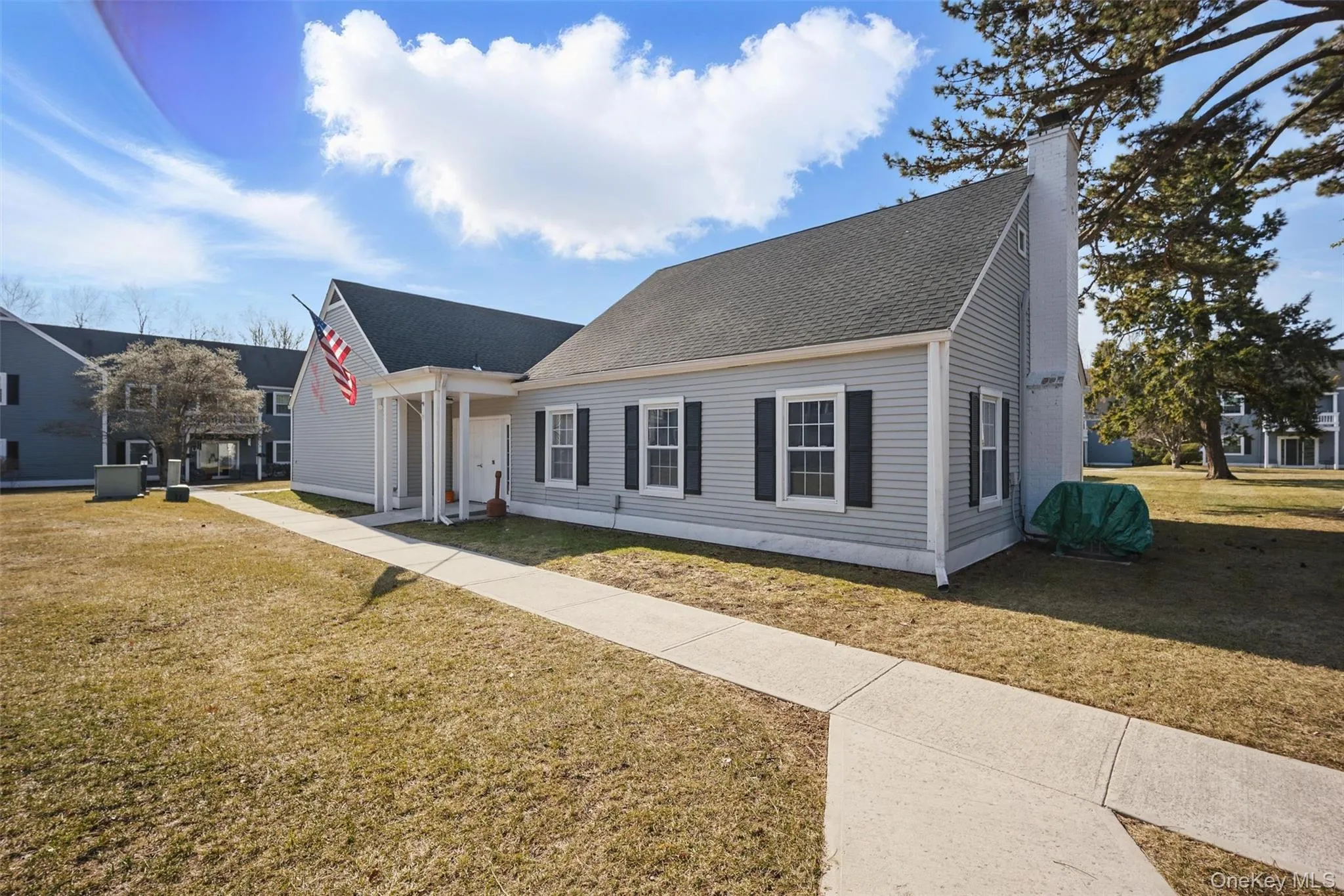 View of front of home with a chimney, a front yard, and roof with shingles View of front of home with a chimney, a front yard, and roof with shingles