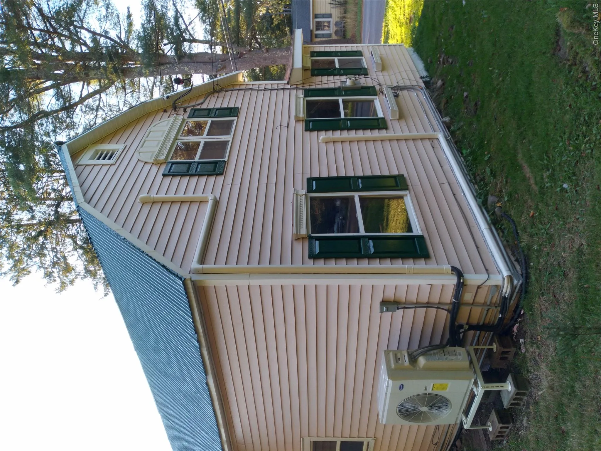 Rear view of house featuring a metal roof, a gambrel roof, and a yard Rear view of house featuring a metal roof, a gambrel roof, and a yard