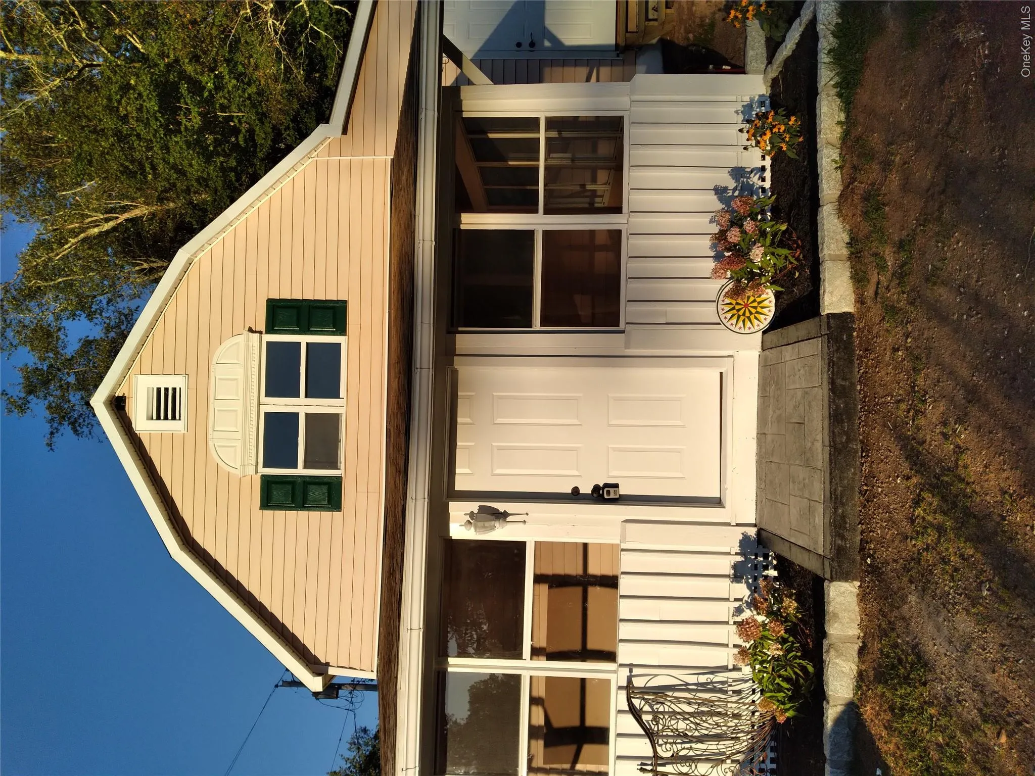 Colonial inspired home featuring a gambrel roof and covered porch Colonial inspired home featuring a gambrel roof and covered porch