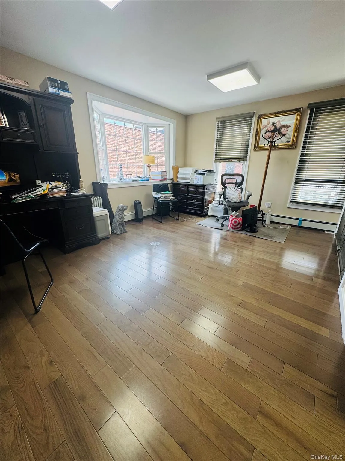 Office space with light wood-style floors and a baseboard radiator Office space with light wood-style floors and a baseboard radiator