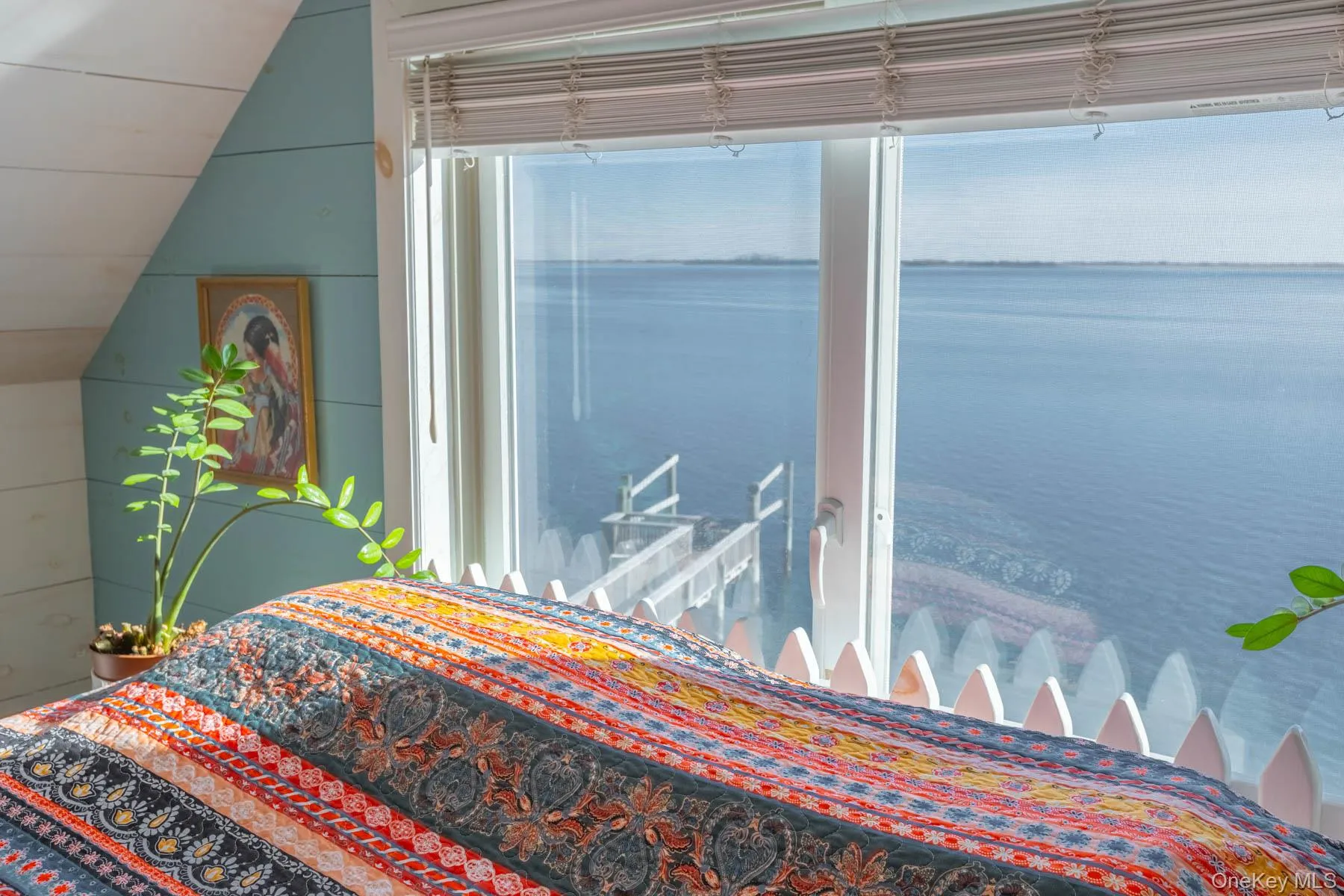 Bedroom featuring lofted ceiling and a water view Bedroom featuring lofted ceiling and a water view