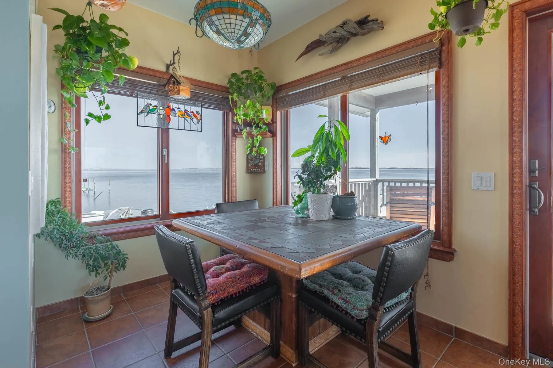 Tiled dining space featuring a water view and baseboards Tiled dining space featuring a water view and baseboards