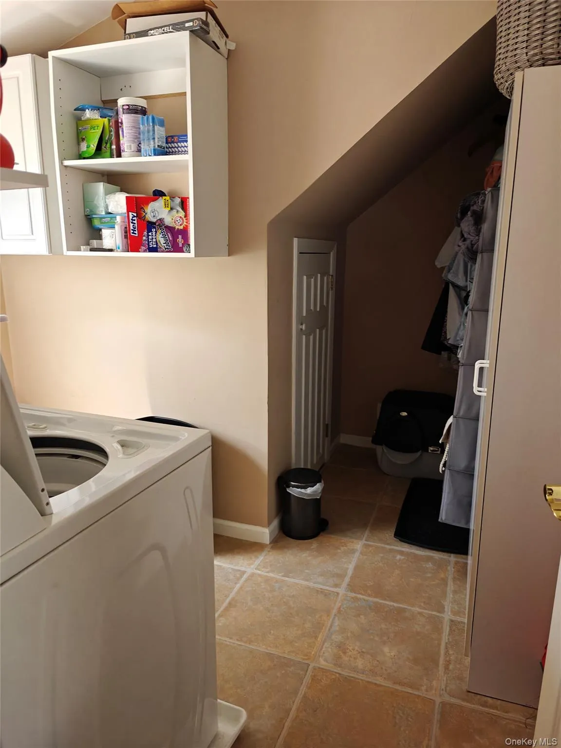 Laundry area featuring washer / clothes dryer and light tile patterned floors Laundry area featuring washer / clothes dryer and light tile patterned floors