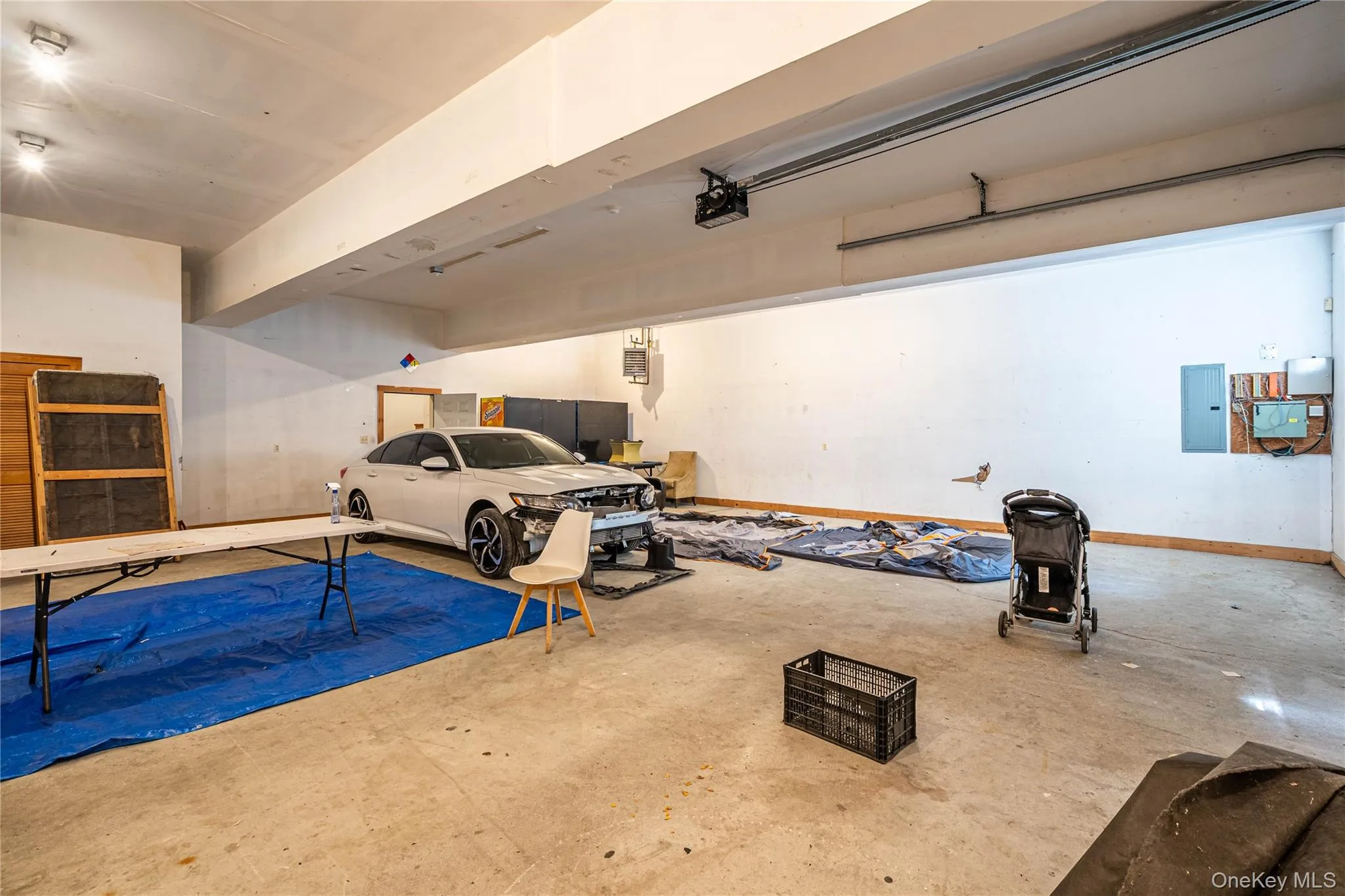 Garage featuring electric panel and a garage door opener Garage featuring electric panel and a garage door opener