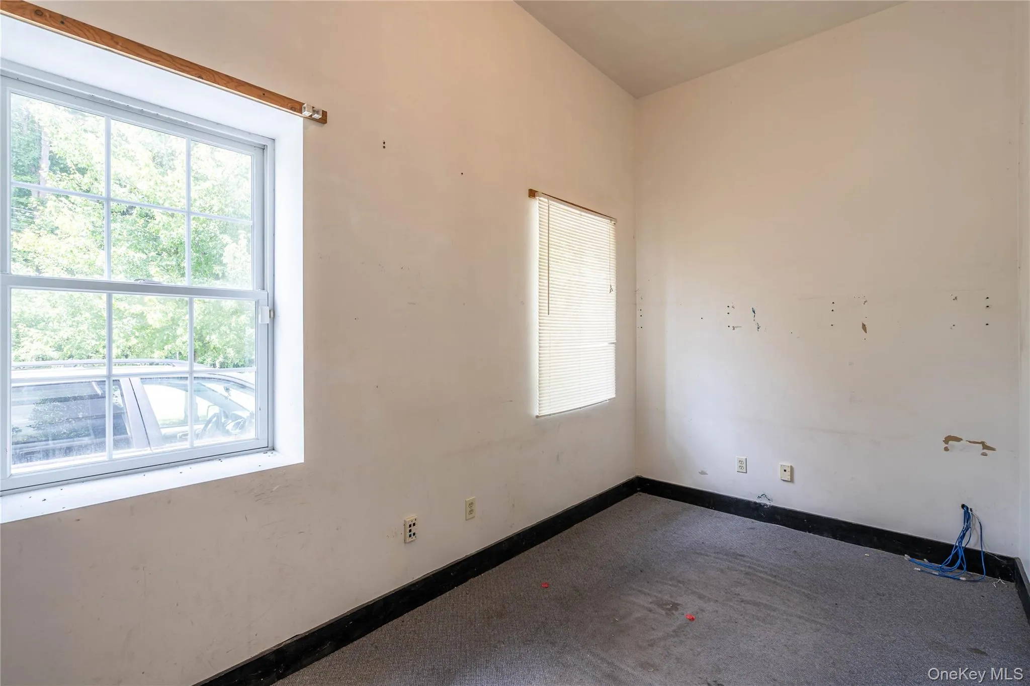 Empty room featuring carpet flooring and baseboards Empty room featuring carpet flooring and baseboards