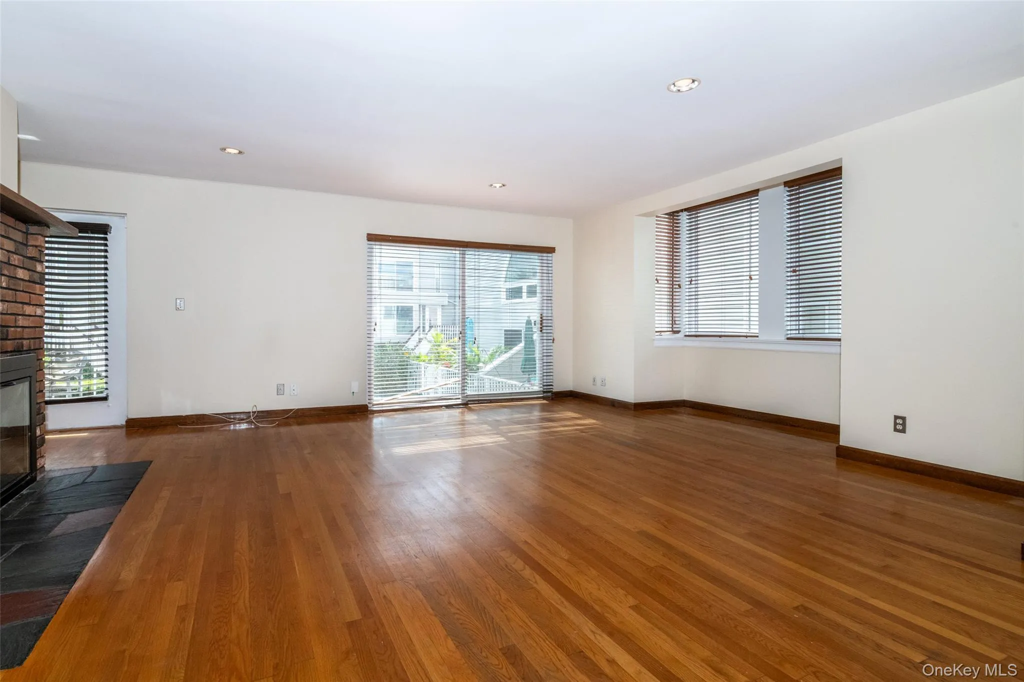 living room with doors to water view balcony featuring healthy amount of natural light, recessed lighting wood burning fireplace living room with doors to water view balcony featuring healthy amount of natural light, recessed lighting wood burning fireplace