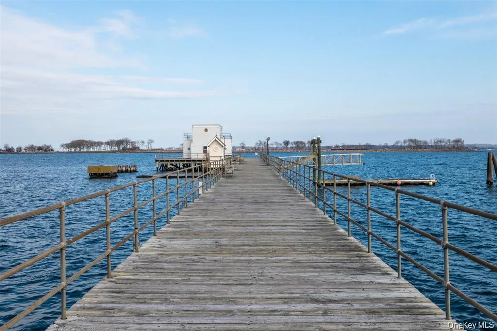 Dock area featuring a water view, with club house Dock area featuring a water view, with club house
