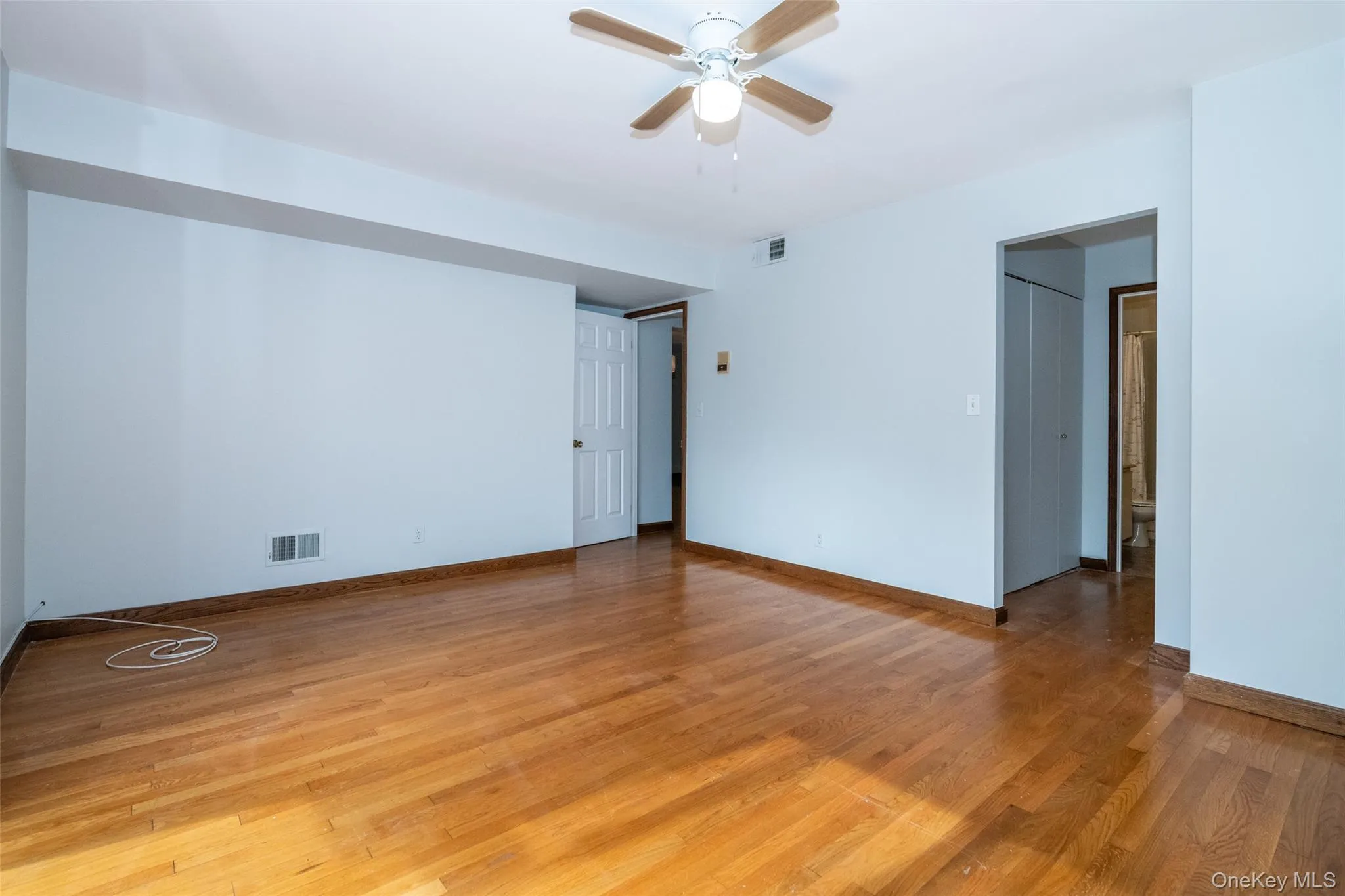 featuring light wood finished floors and a ceiling fan featuring light wood finished floors and a ceiling fan