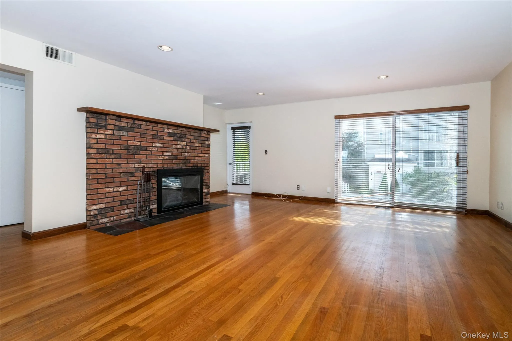 living room with wood burning fireplace, plenty of natural light, a fireplace, wood finished floors, and recessed lighting living room with wood burning fireplace, plenty of natural light, a fireplace, wood finished floors, and recessed lighting