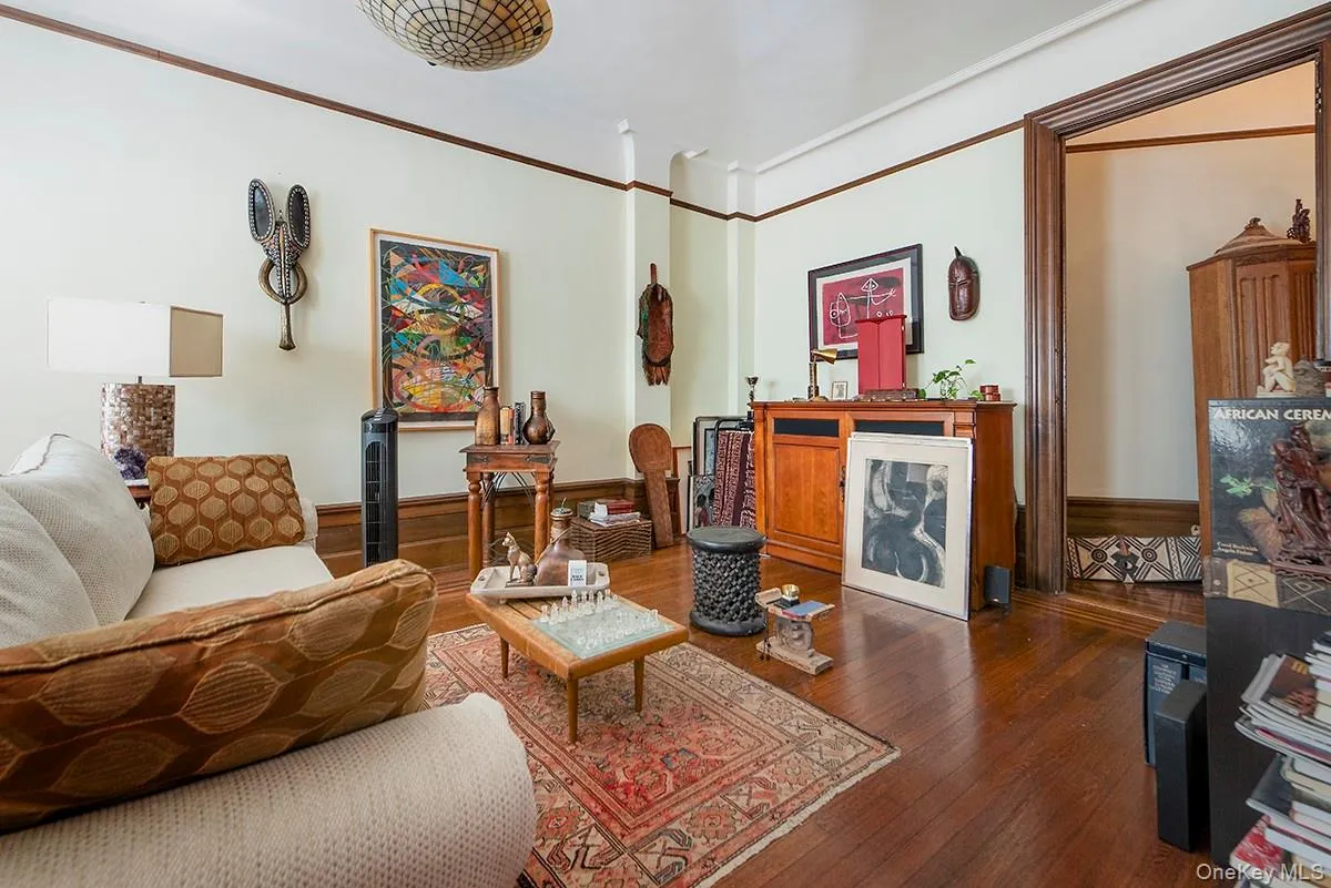 Living area with hardwood / wood-style flooring and ornamental molding Living area with hardwood / wood-style flooring and ornamental molding