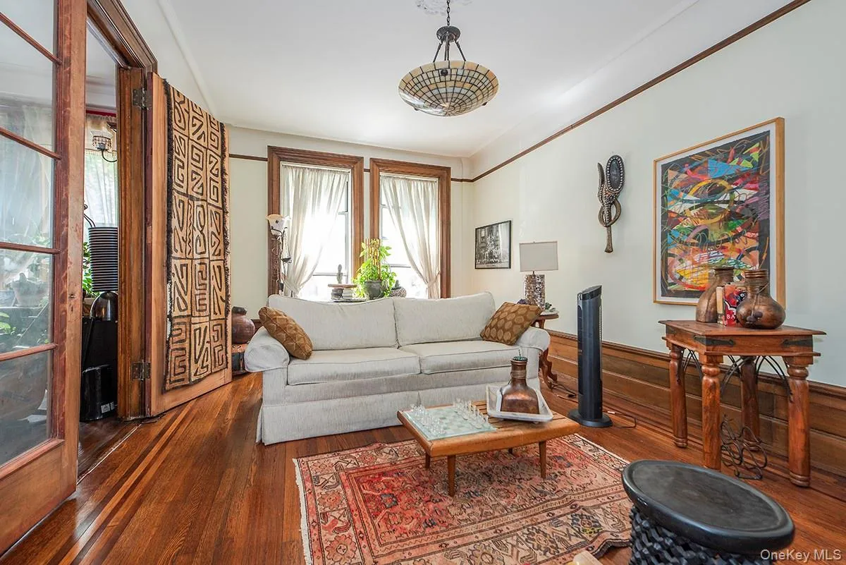 Living area with wood-type flooring, ornamental molding, and wainscoting Living area with wood-type flooring, ornamental molding, and wainscoting