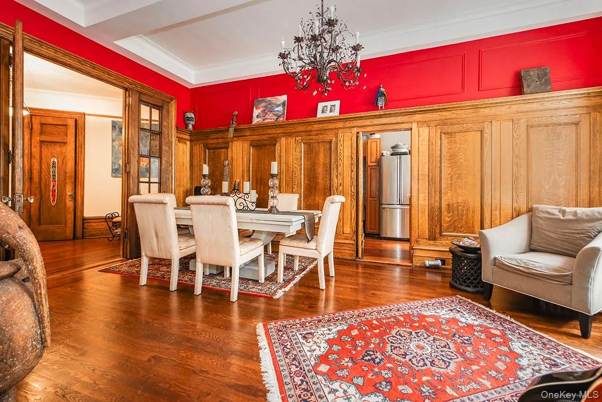 Dining room with dark wood-style flooring, a chandelier, and ornamental molding Dining room with dark wood-style flooring, a chandelier, and ornamental molding