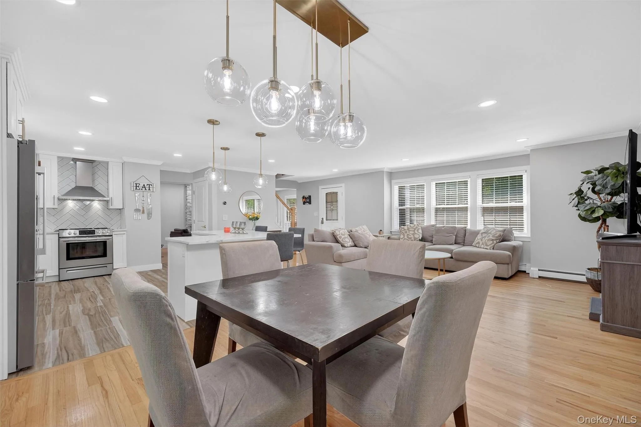 Dining space featuring light wood finished floors, recessed lighting, stairs, and a baseboard heating unit Dining space featuring light wood finished floors, recessed lighting, stairs, and a baseboard heating unit