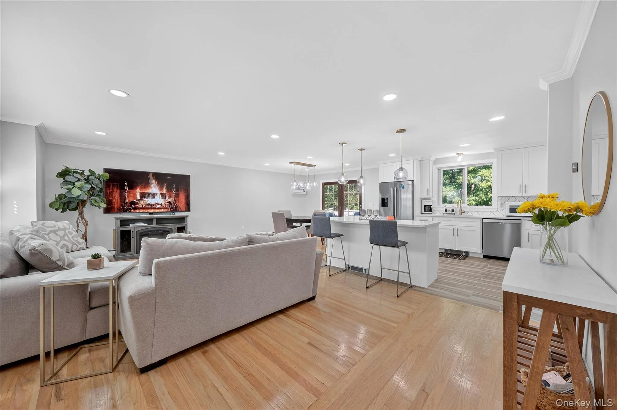Living room featuring ornamental molding, light wood finished floors, and recessed lighting Living room featuring ornamental molding, light wood finished floors, and recessed lighting