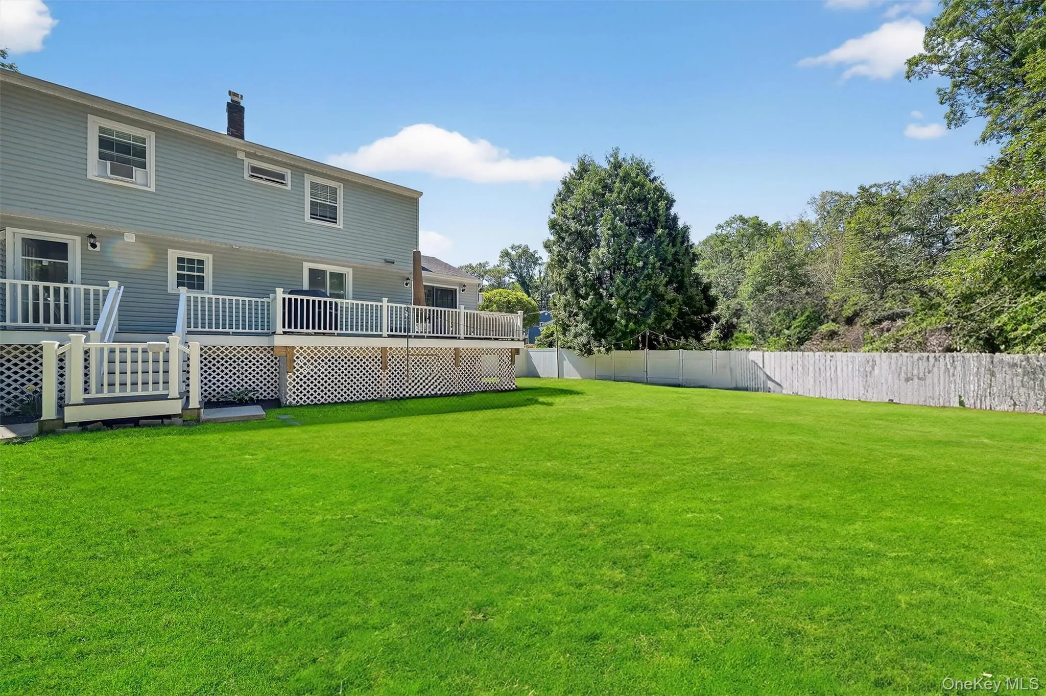 Fenced backyard with a wooden deck Fenced backyard with a wooden deck
