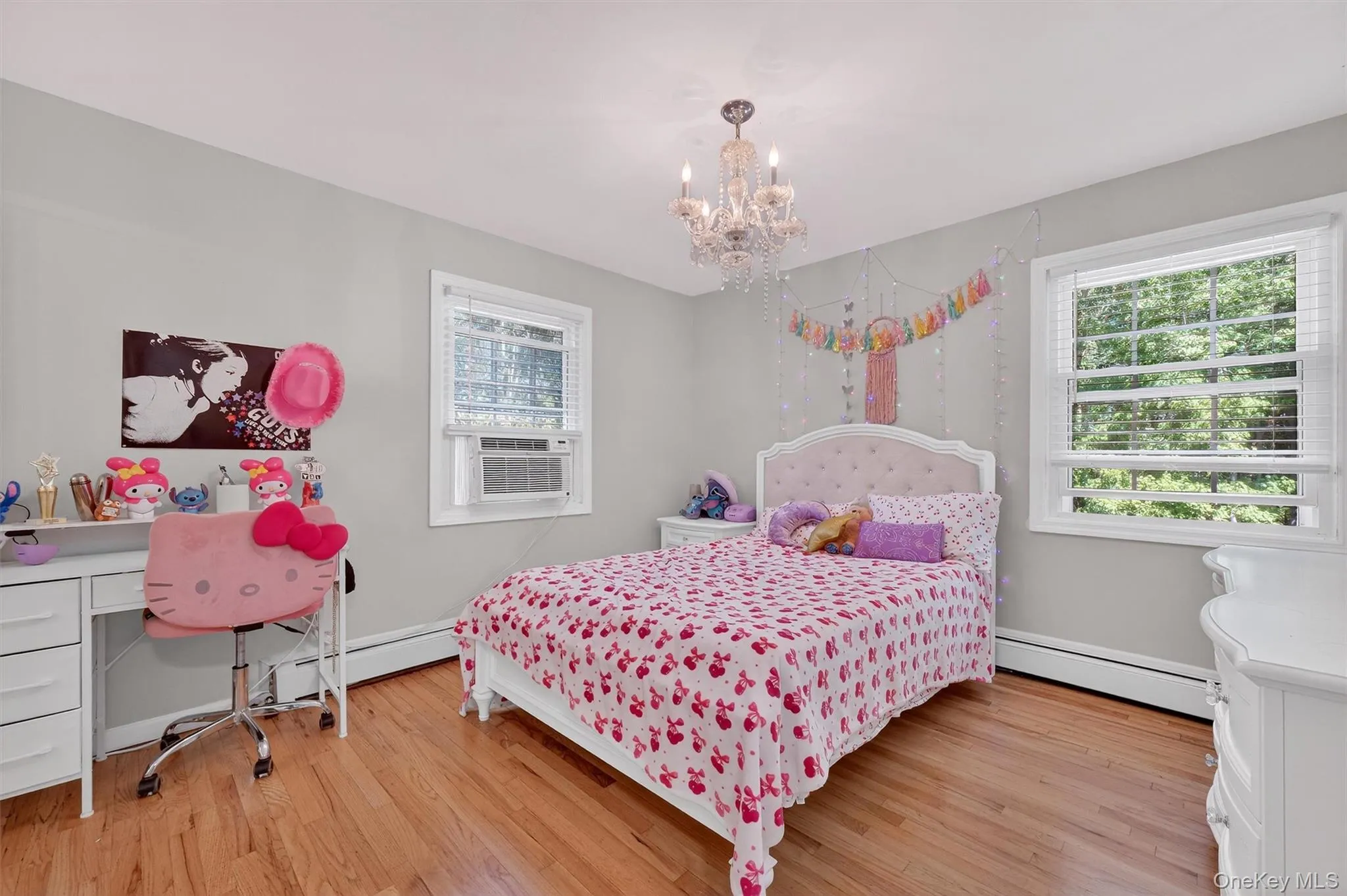 Bedroom with a baseboard radiator, light wood finished floors, a chandelier, and cooling unit Bedroom with a baseboard radiator, light wood finished floors, a chandelier, and cooling unit