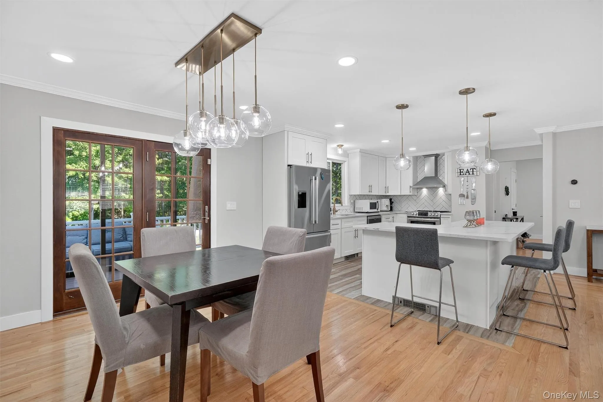 Dining room with crown molding, light wood-style floors, and recessed lighting Dining room with crown molding, light wood-style floors, and recessed lighting