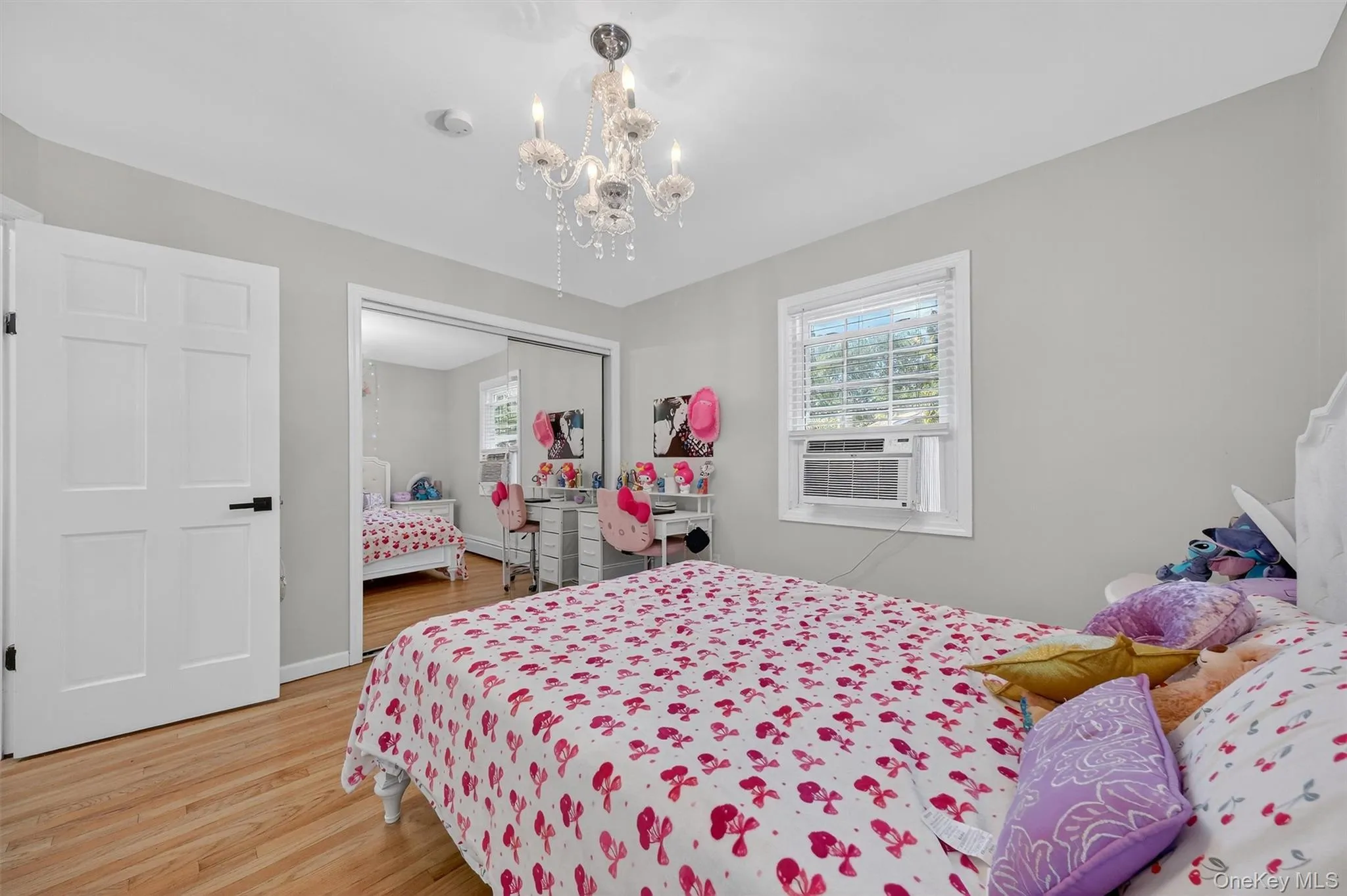 Bedroom with light wood-style floors, multiple windows, a closet, and a chandelier Bedroom with light wood-style floors, multiple windows, a closet, and a chandelier