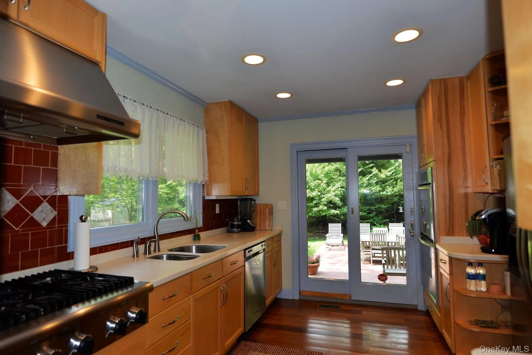 Kitchen featuring open shelves, plenty of natural light, under cabinet range hood, backsplash, and recessed lighting