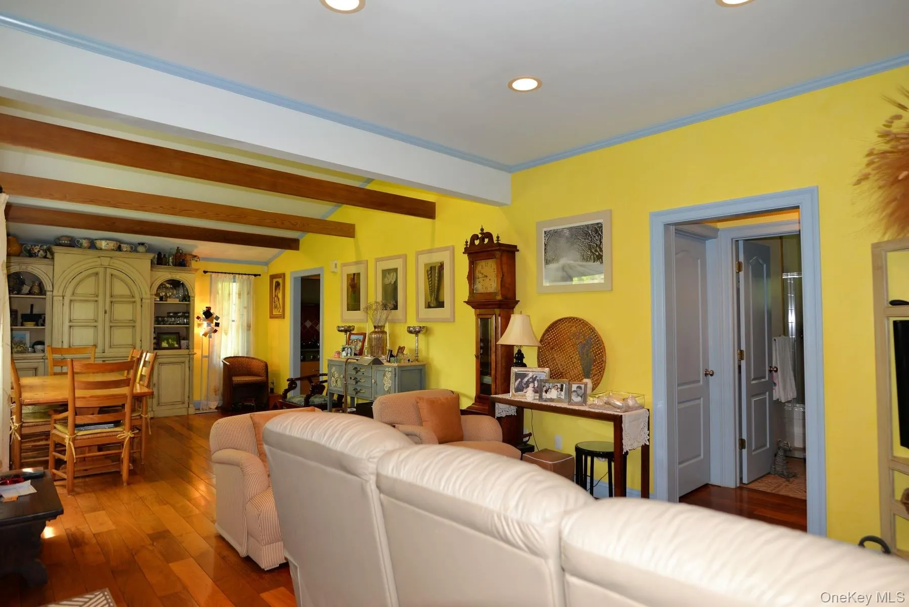 Living area with hardwood / wood-style floors, beam ceiling, and recessed lighting
