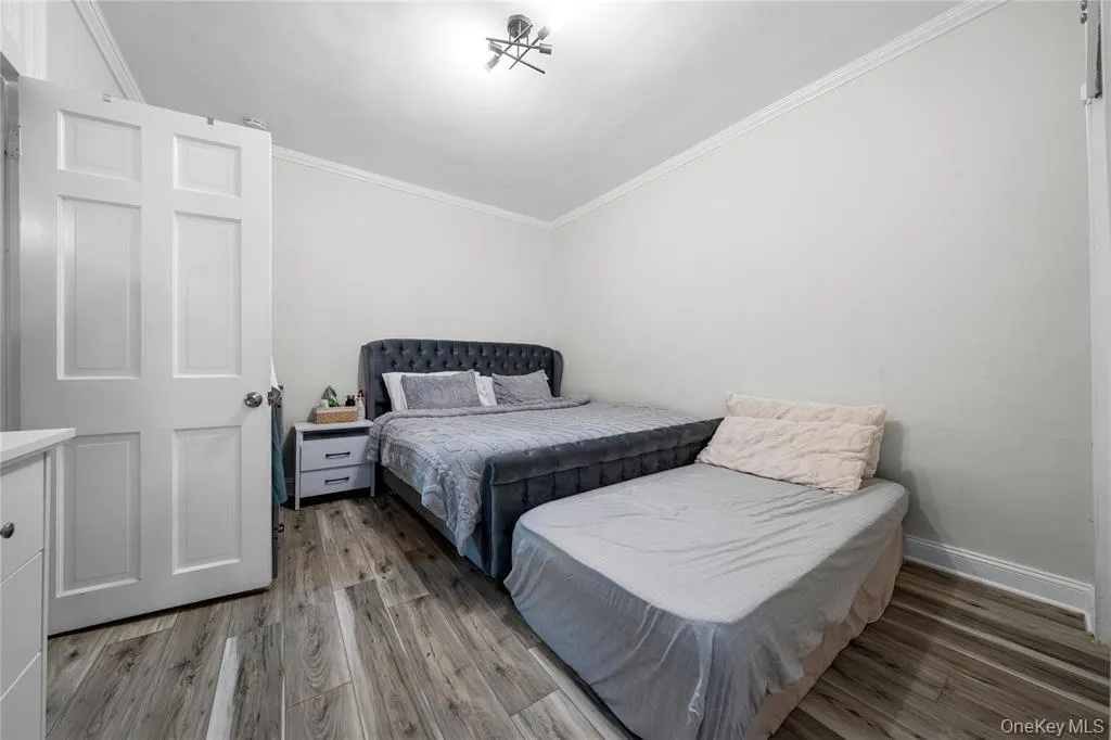 Bedroom with ornamental molding and light wood finished floors Bedroom with ornamental molding and light wood finished floors