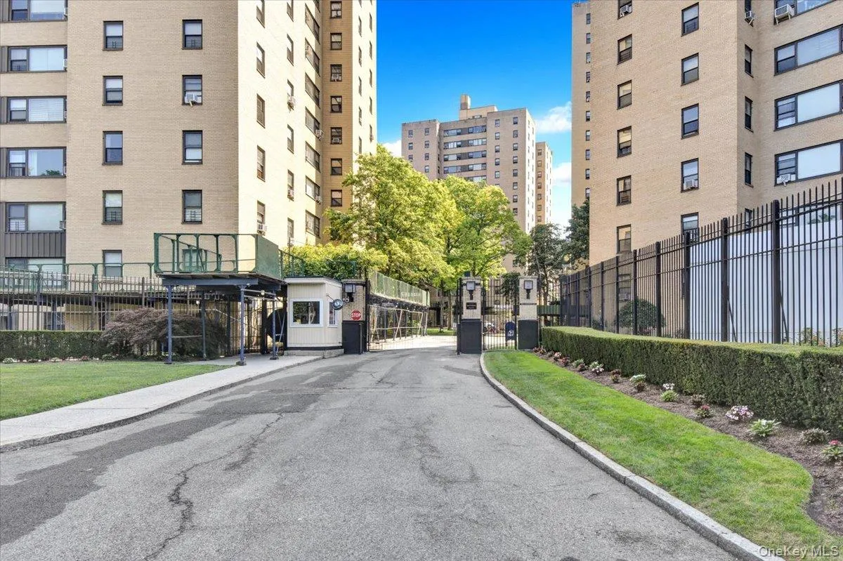 View of asphalt street with curbs, sidewalks, a gated entry, and a gate View of asphalt street with curbs, sidewalks, a gated entry, and a gate