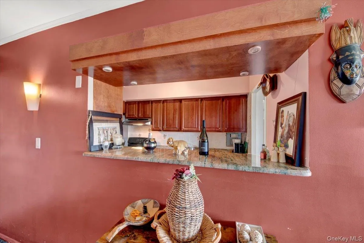 Kitchen featuring brown cabinets and under cabinet range hood Kitchen featuring brown cabinets and under cabinet range hood