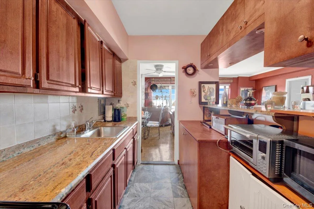 Kitchen featuring brown cabinets, stainless steel microwave, and ceiling fan Kitchen featuring brown cabinets, stainless steel microwave, and ceiling fan