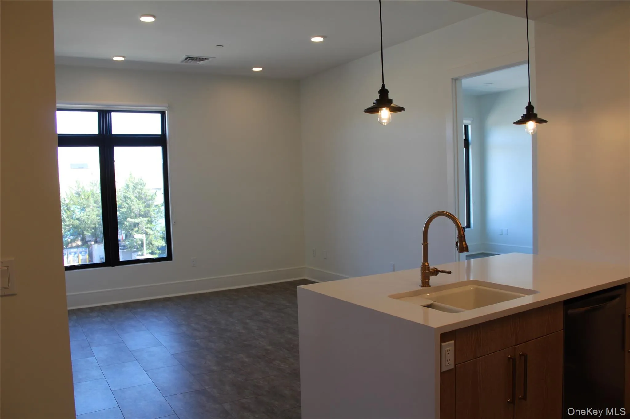 Kitchen with dishwasher, pendant lighting, light stone counters, recessed lighting, and brown cabinets Kitchen with dishwasher, pendant lighting, light stone counters, recessed lighting, and brown cabinets