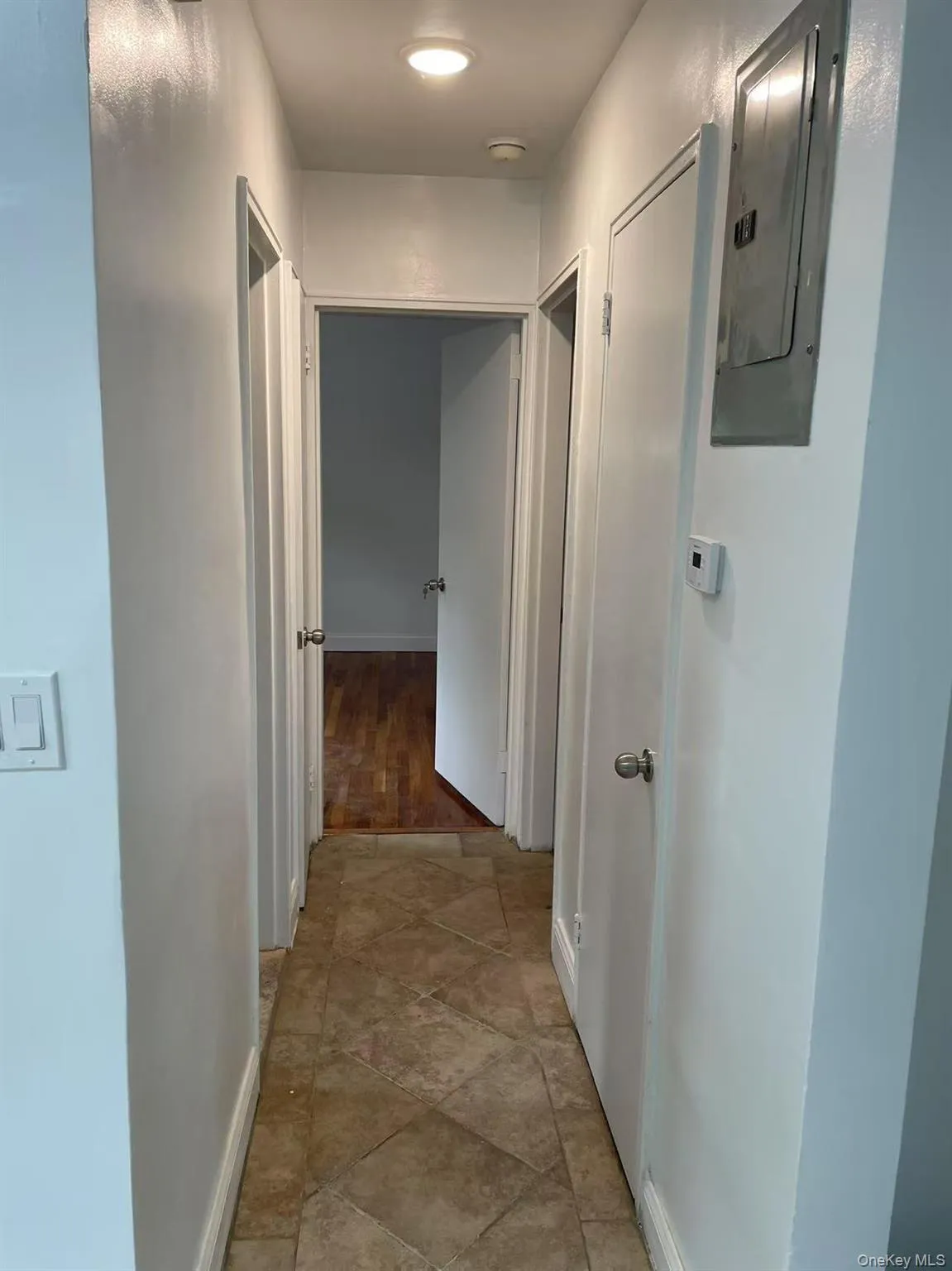 Hallway featuring baseboards and electric panel Hallway featuring baseboards and electric panel