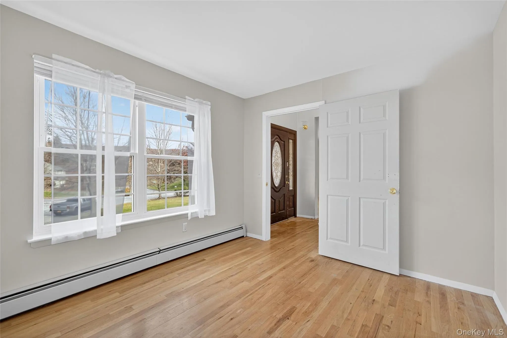 Empty room featuring baseboard heating and light wood-type flooring Empty room featuring baseboard heating and light wood-type flooring