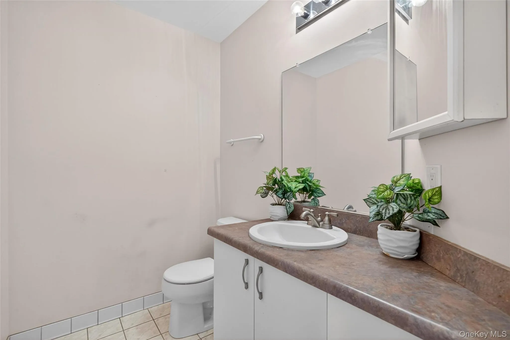 Bathroom featuring light tile patterned floors and vanity Bathroom featuring light tile patterned floors and vanity
