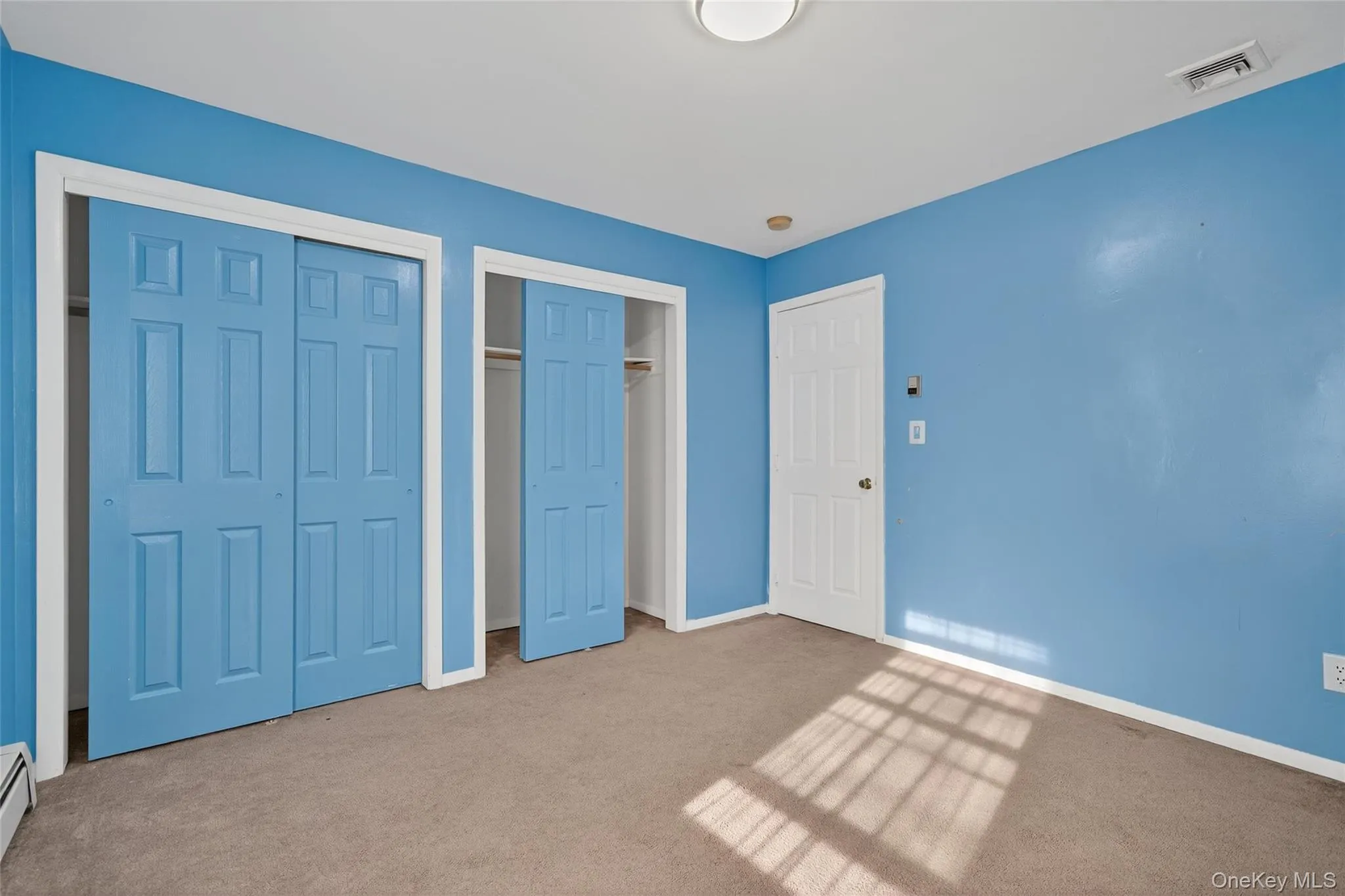 Unfurnished bedroom featuring multiple closets and carpet flooring Unfurnished bedroom featuring multiple closets and carpet flooring