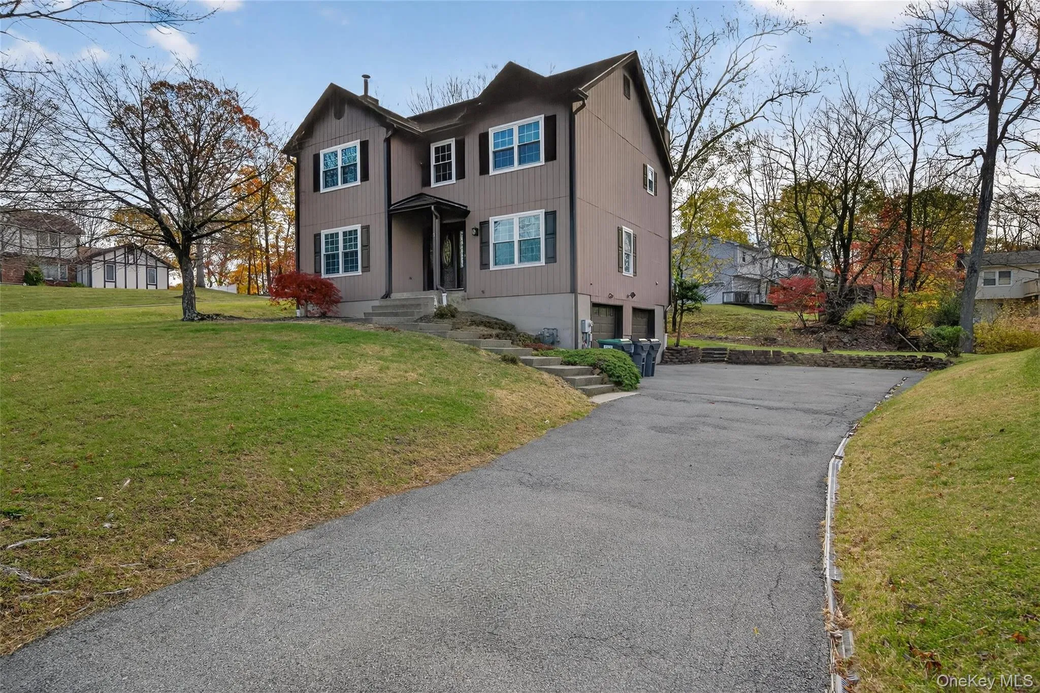 Traditional-style house with a garage, a front yard, and asphalt driveway Traditional-style house with a garage, a front yard, and asphalt driveway